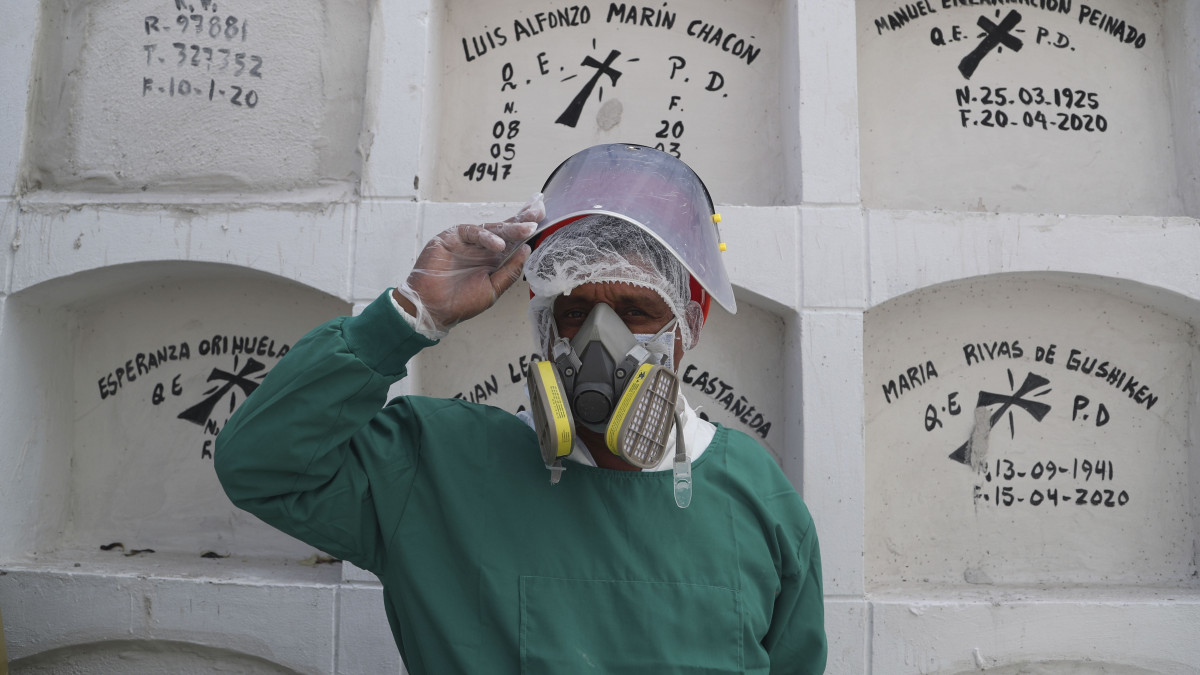 A koronavírus-járvány miatt védőöltözetet viselő dolgozó a limai El Angel temető urnafülkéi előtt 2020. május 7-én.