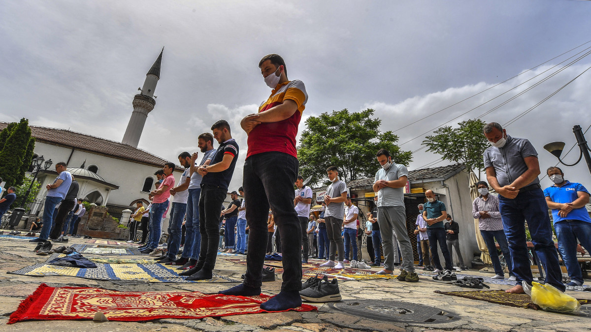 Szájmaszkban és anélkül imádkozó muzulmán férfiak egy mecset előtt az észak-macedóniai fővárosban, Szkopjéban 2020. május 15-én, a koronavírus-járvány idején. A muzulmán hívők a március közepén elrendelt kijárási korlátozások részleges feloldása után először vehettek részt a pénteki imán Észak-Macedóniában.