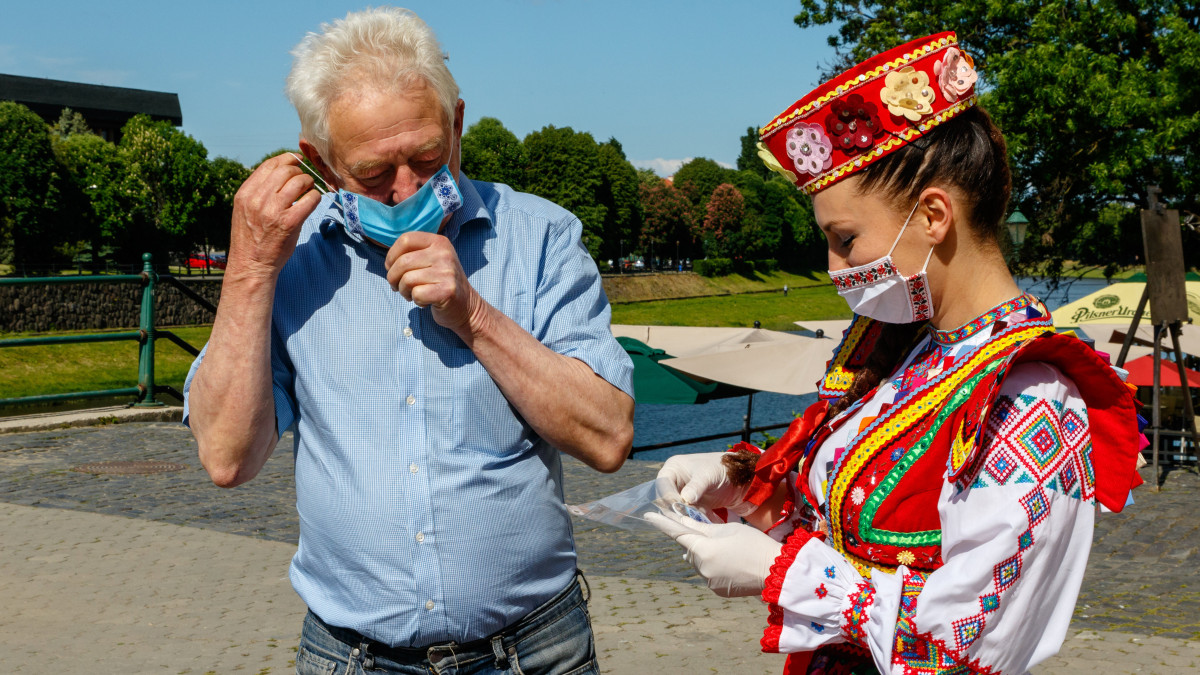 Hímzett védőmaszkot oszt a járókelőknek a Kárpátaljai Érdemes Népi Együttes egyik népviseletbe öltözött tagja az ukrán hímzett ing, a Visivanka világnapja alkalmából Ungvár belvárosában 2020. május 21-én.