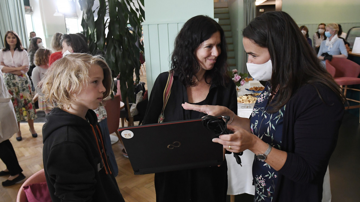 Novák Katalin család- és ifjúságügyért felelős államtitkár, a Nők Magyarországért Klub elnöke egy laptopot ad át egy gyereknek Budapesten az Egyszülős Központban 2020. május 27-én. A klub száz, a digitális oktatáshoz szükséges laptoppal támogatja az egyszülős családokat.