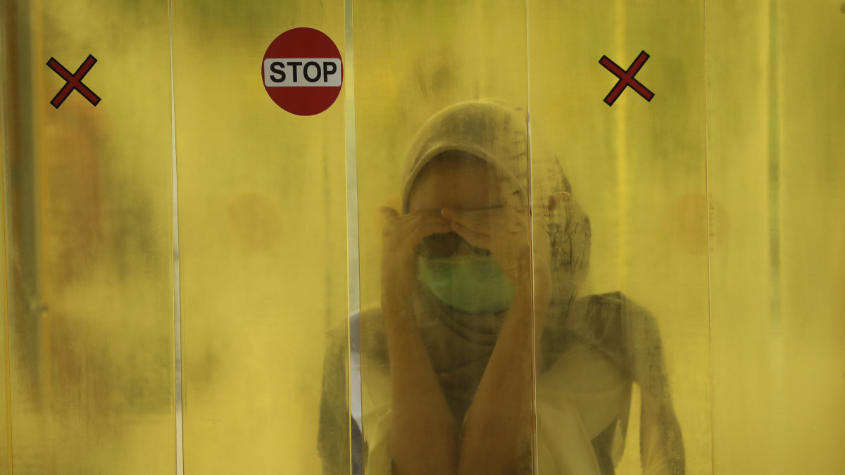Fertőtlenítő kapun keresztül lép be egy nő egy jakartai bevásárlóközpontba 2020. június 9-én. Indonéziában a kormány feloldotta a koronavírus-járvány miatt két hónapja elrendelt korlátozásokat.
