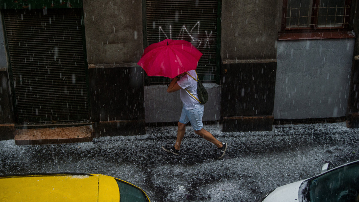 Esernyőt tartó férfi a jégesőben Budapest belvárosában 2020. június 14-én.