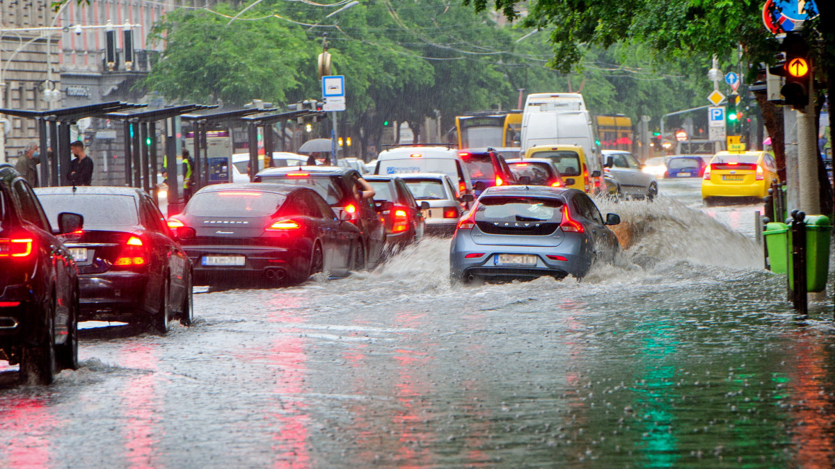 A vihar után összegyűlt esővízben haladnak járművek a budapesti Teréz körúton, az Oktogonnál 2020. június 14-én.