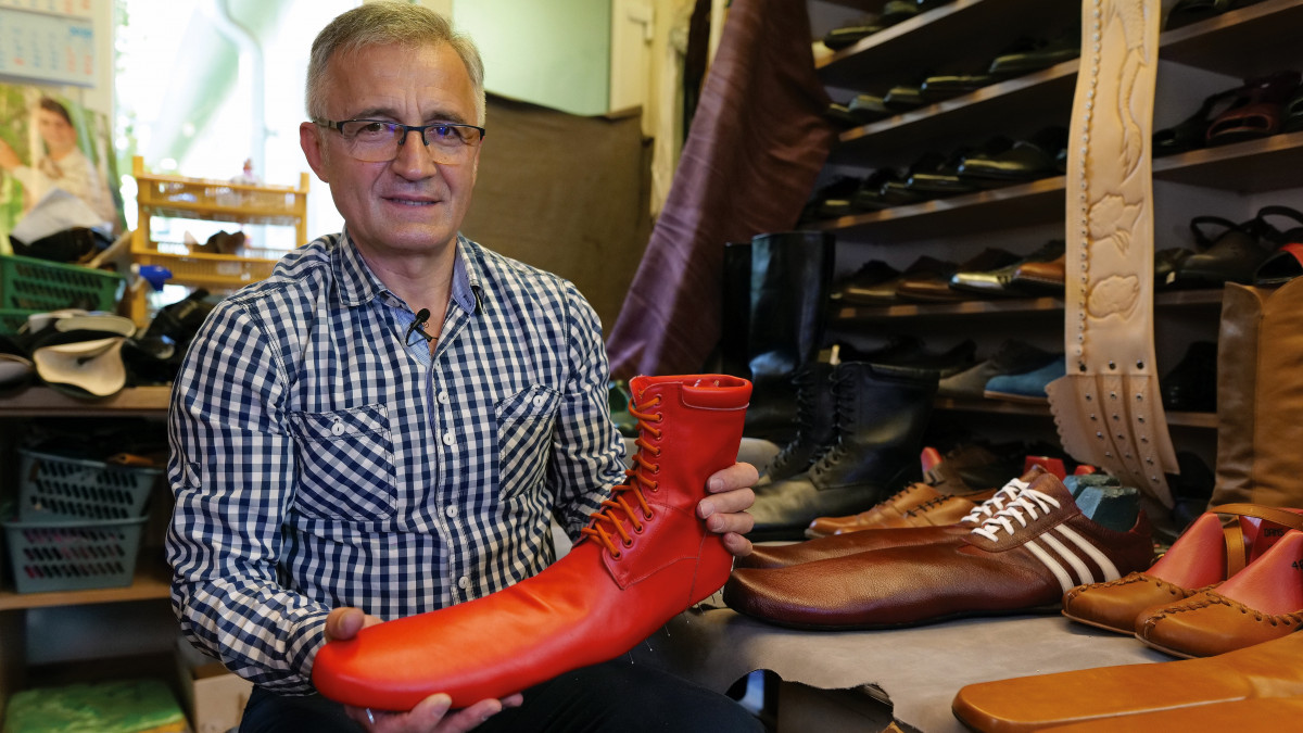 Grigore Lup román cipész kezében egy nagy méretű, a biztonságos távolságtartásra alkalmas női cipővel kolozsvári műhelyében 2020. június 4-én. Az 55 éves Lup kézzel készíti a saját maga tervezte, 75 centiméter hosszúságú bőrlábbeliket, amelyeknek párját 100 euróért árulja. Az óriáscipőkre már érkeztek rendelések külföldről is.