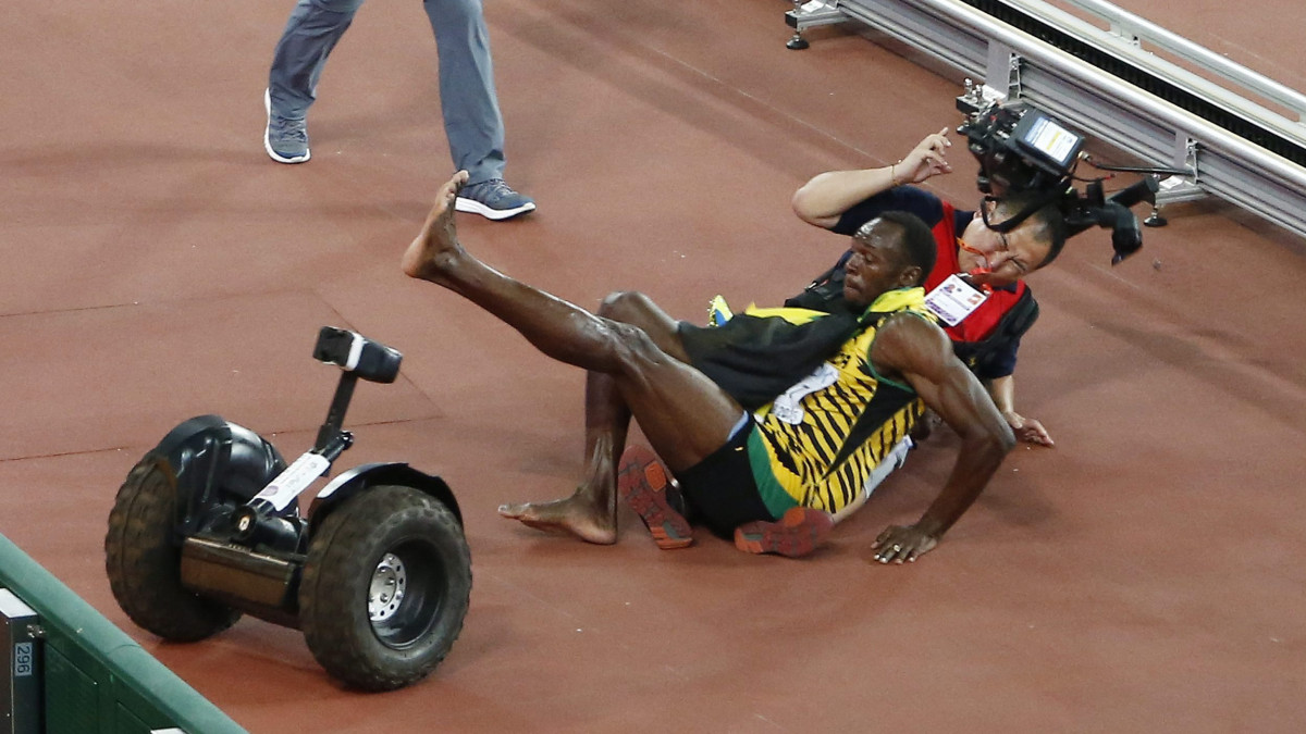 Peking, 2015. augusztus 27.Egy operatőr egy segway-jel belehajt a jamaicai Usain Boltba, miután megnyerte a férfi 200 méteres síkfutás döntőjét a pekingi atlétikai világbajnokságon 2015. augusztus 27-én. (MTI/EPA/Rolex Dela Pena)