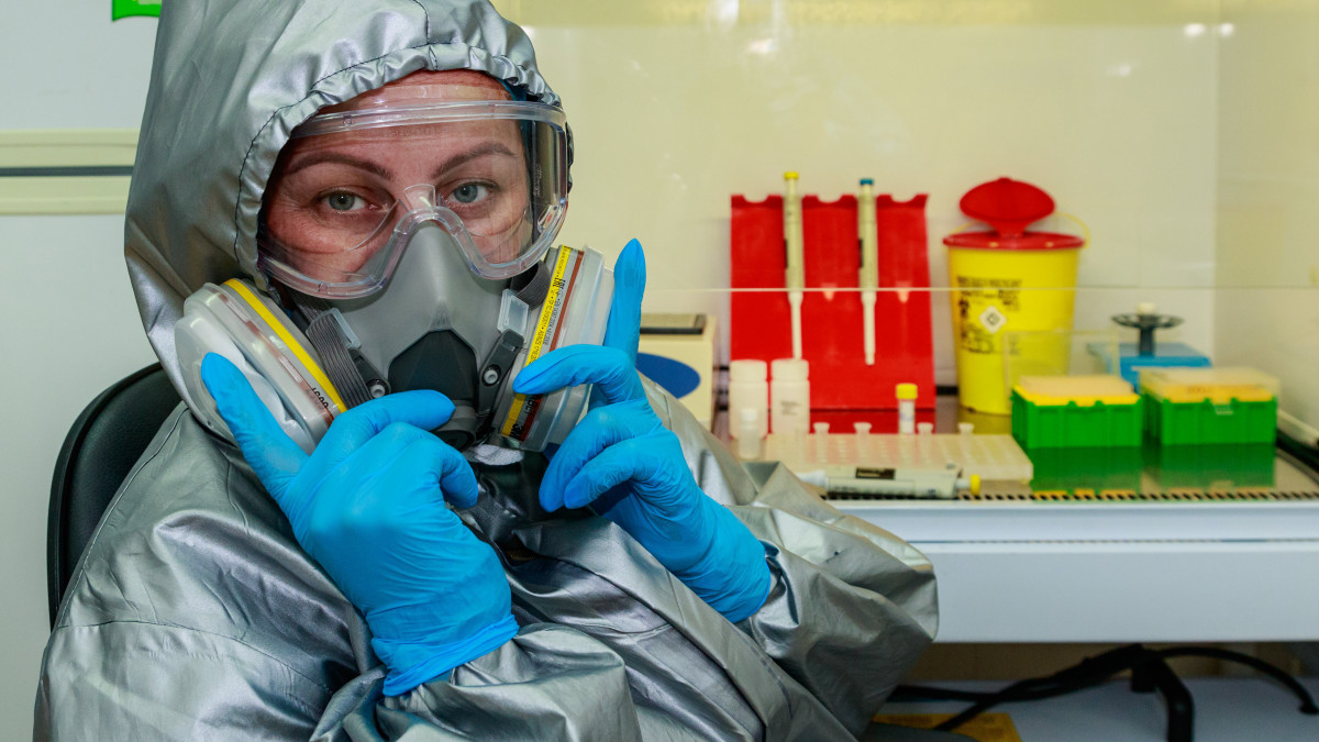 Koronavírus-teszthez beérkezett mintákat vizsgáló orvos mutatja a védőfelszerelését a Kárpátaljai Megyei Népegészségügyi Központ laboratóriumában Ungváron 2020. május 8-án.
