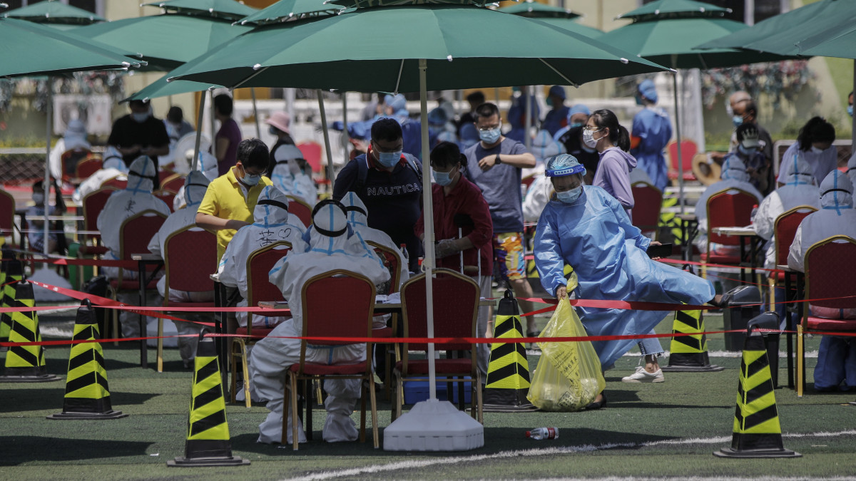 Koronavírusteszteket végeznek helyi lakosokon egy pekingi tesztközpont előtt 2020. június 18-án. Pekingben az elmúlt napokban azonosítottak egy nagybani piachoz köthető járványgócot, ezért széles körű tesztelést végeztek a piachoz köthető emberek körében. A koronavírus-járvány újraéledése miatt a 21 millió lakosú kínai fővárosban 29 lakóövezetet lezártak, bezártak az óvodák, az általános és középiskolákban távtanításra tértek át, az egyetemeken pedig felfüggesztették az oktatást. Június 17-én 21 új koronavírussal fertőzött személyt azonosítottak.