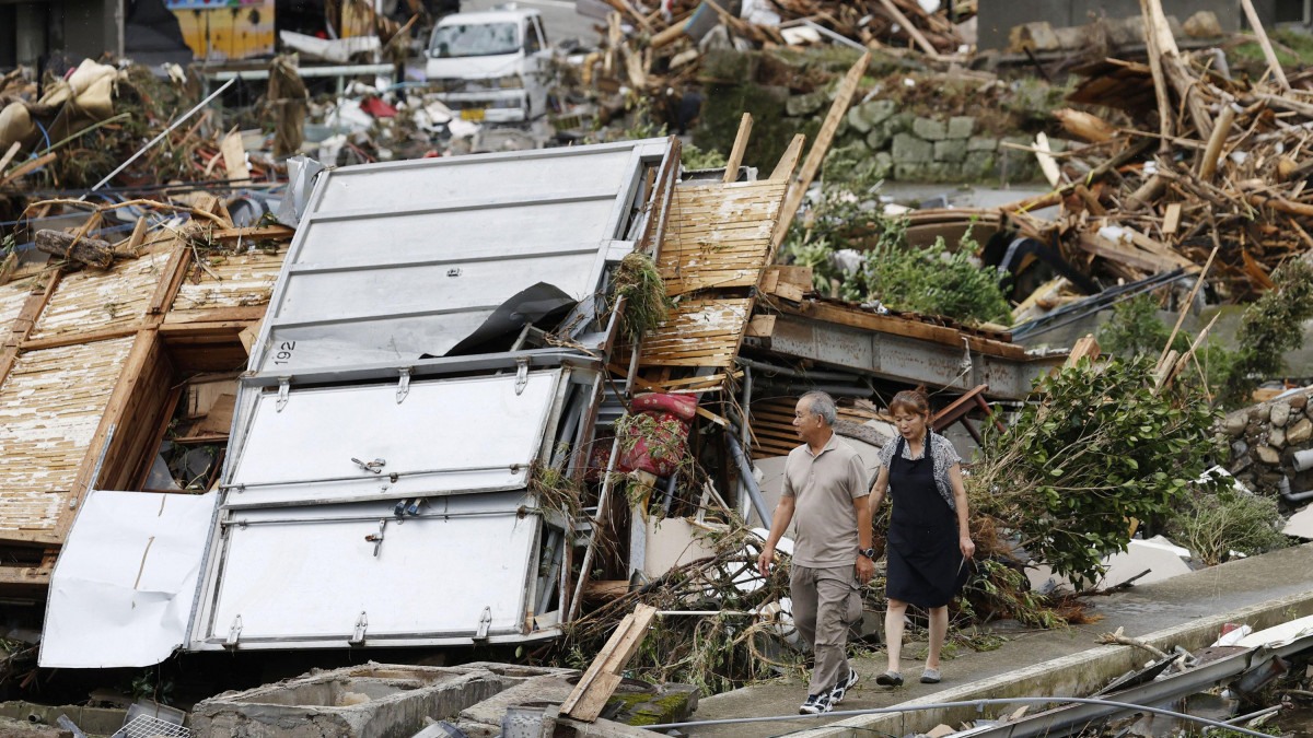 A pusztítás nyomait nézi egy pár a Kumamoto prefektúrában fekvő Kumamurában történt áradást követően 2020. július 6-án. Mintegy harminc ember vesztette életét a felhőszakadások okozta földcsuszamlásoknak és áradásoknak Japánban. Tucatnyian eltűntek, lakosok tízezreit kellett evakuálni.