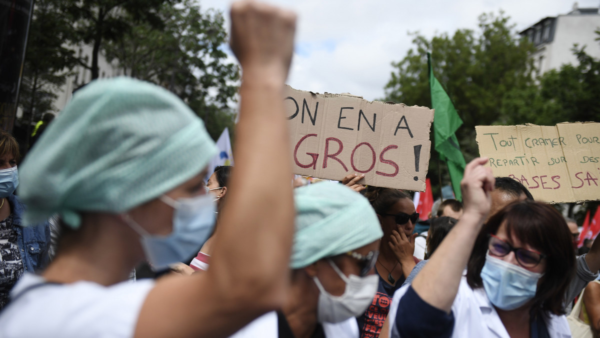A francia kormány ellen tüntető egészségügyi dolgozók Párizsban 2020. július 14-én. Az egészségügyi dolgozókat képviselő szakszervezetek jobb munkakörülményeket, magasabb fizetést, és több állami támogatást követeltek, valamint, hogy szüntessék meg azt a gyakorlatot, hogy a kórházi dolgozókkal rövid távú munkaszerződést kötnek.