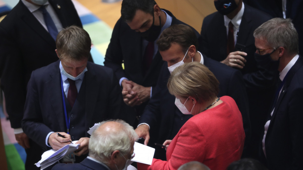 Angela Merkel (k) Pedro Sánchez spanyol miniszterelnökkel (k, a háttérben) és Emmanuel Macron francia elnökkel (j3) beszél az Európai Unió kétnaposra tervezett brüsszeli csúcstalálkozójának negyedik napi ülésén 2020. július 20-án. A tagállamok vezetői az unió következő hétéves költségvetéséről és az ahhoz kapcsolódó, a koronavírus-járvány okozta gazdasági és társadalmi károk helyreállítását célzó pénzügyi támogatási csomagról tanácskoznak.