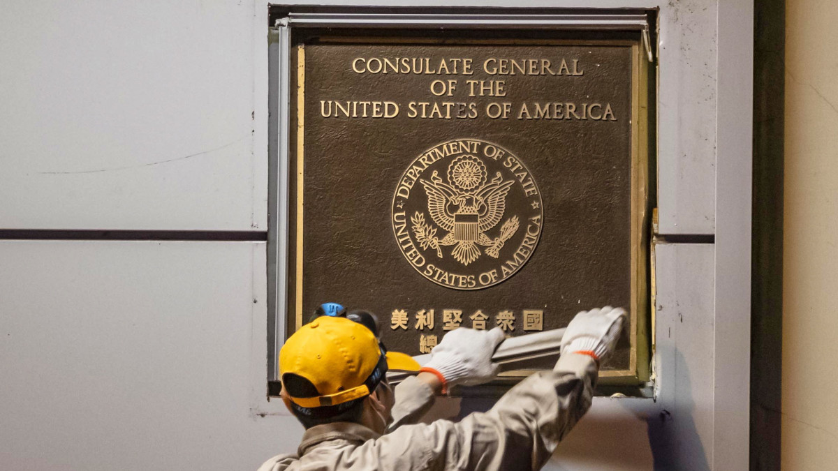 Az Egyesült Államok csengtui főkonzulátusának kapuja mellől leszereli a névtáblát egy dolgozó 2020. július 26-án. A kínai kormány elrendelte a diplomáciai képviselet bezárását Csengtuban válaszlépésként arra, hogy Washington bezáratta Kína houstoni főkonzulátusát.