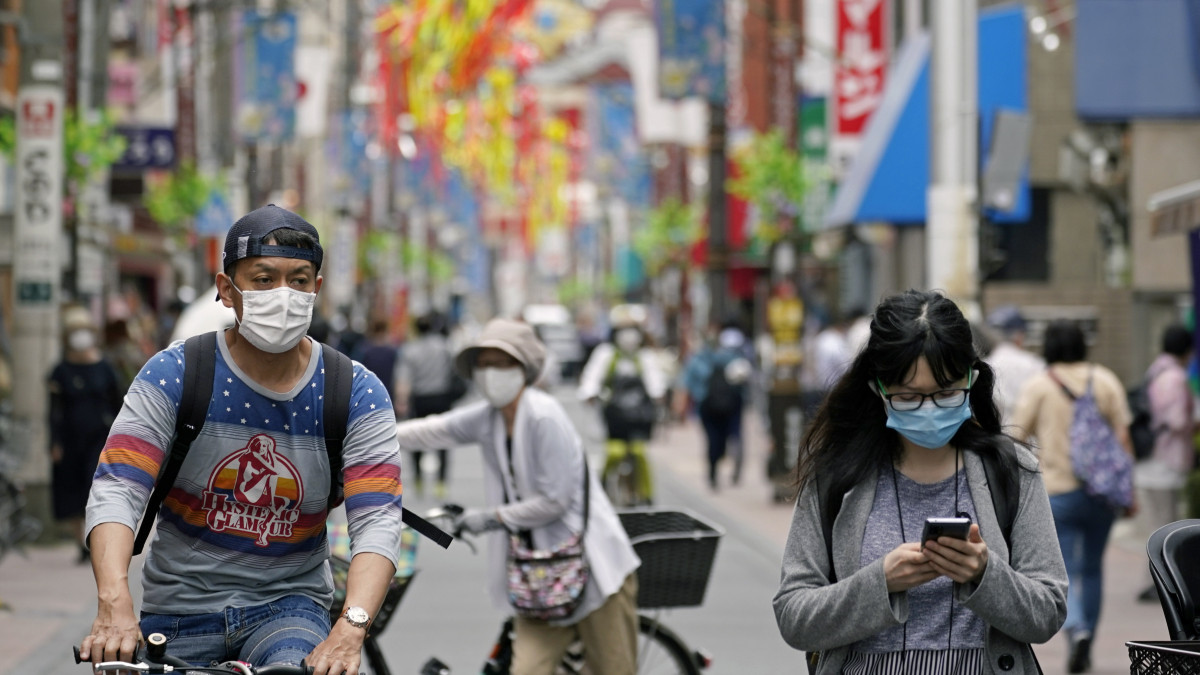 Védőmaszkos járókelők egy tokiói bevásárlóutcában 2020. július 3-án. A hatóságok 124 új koronavírus-fertőzöttet jelentettek a nap folyamán, ez a legmagasabb szám az elmúlt két hónapban.