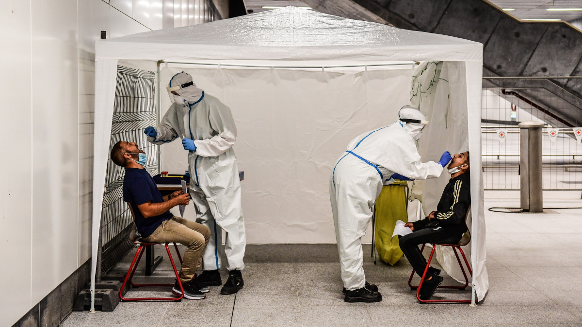Ingyenes koronavírus-tesztet végeznek az utasokon a Vöröskereszt dolgozói Berlin központi pályaudvarán 2020. augusztus 18-án.