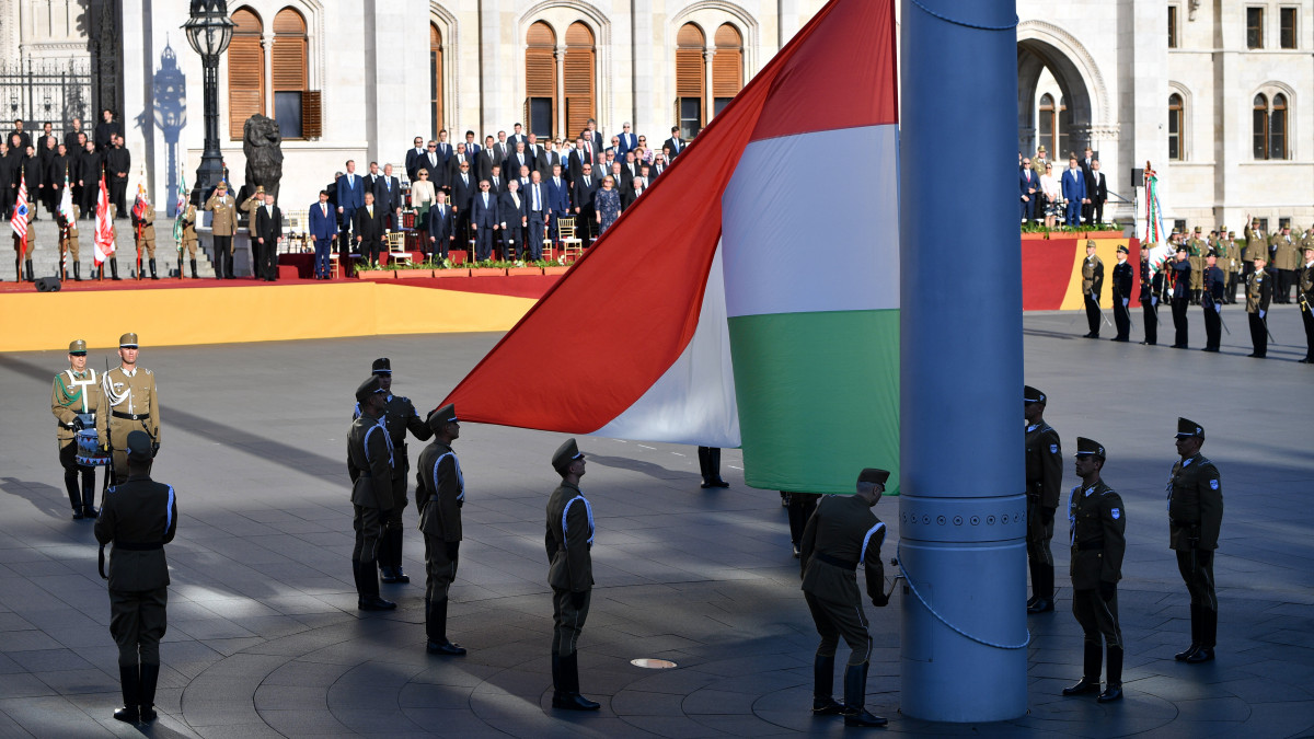 Katonai tiszteletadás mellett, a közjogi méltóságok jelenlétében felvonják Magyarország nemzeti lobogóját az államalapító Szent István király ünnepe alkalmából tartott díszünnepségen és tisztavatáson az Országház előtt, a Kossuth Lajos téren 2020. augusztus 20-án.