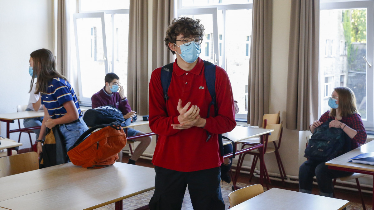 Védőmaszkot viselő diákok osztálytermükben a belgiumi Izel város egyik iskolájában 2020. május 19-én. Belgiumban előző nap ismét enyhítettek a koronavírus-járvány miatt bevezetett korlátozásokon, újra kinyitottak az iskolák. Az oktatási intézményekben kötelező a fizikai távolságtartás, a maszk viselése és a gyakori kézfertőtlenítés.