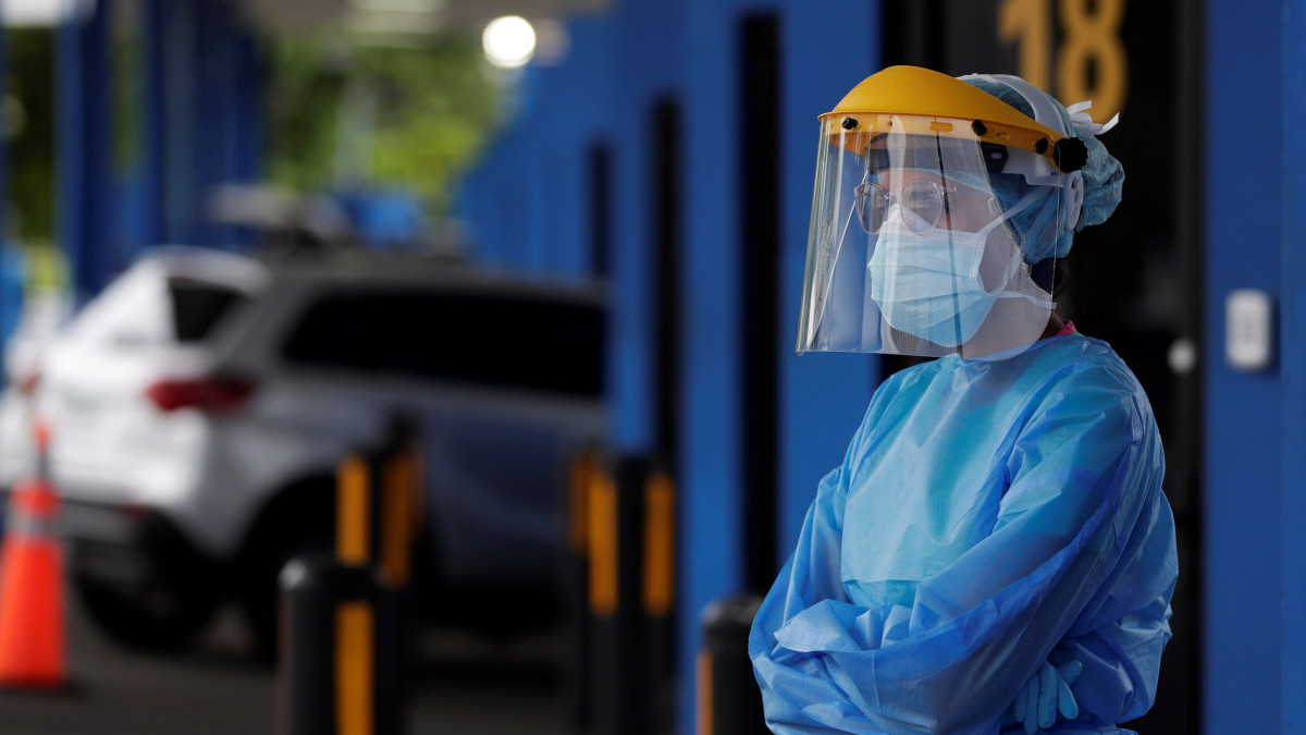 Koronavírustesztre érkezőket vár egy egészségügyi alkalmazott egy panamavárosi autós tesztközpontban 2020. július 14-én. Panamában eddig 48 096 koronavírussal fertőzöttet azonosítottak, 960-an életüket veszítették.