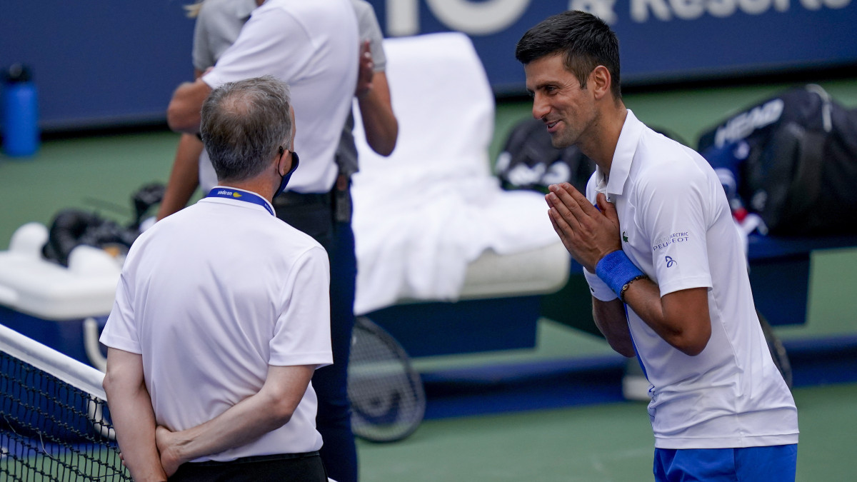 Novak Djokovic szerb versenyző (j) a mérkőzésvezetővel beszél, miután labdája torkon találta az egyik vonalbírót a spanyol Pablo Carreno-Busta elleni nyitó szettben az amerikai nyílt teniszbajnokság férfi versenyének nyolcaddöntőjében a New York-i Flushing Meadowsban 2020. szeptember 6-án. A vonalbírót el kellett szállítani a helyszínről, Djokovicot pedig kizárták.