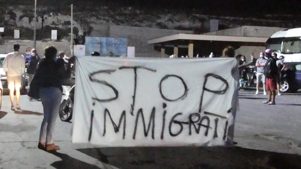 Helyi lakosok tüntetnek a bevándorlás ellen az olaszországi Lampedusa szigetén 2020. augusztus 30-án, miután egyetlen hajóval 450 illegális bevándorló érkezett, és a helyi migránstábor ismét zsúfolásig megtelt. Salvatore Martello polgármester általános sztrájkot hirdetett, hogy kikényszerítse a sziget lezárását.