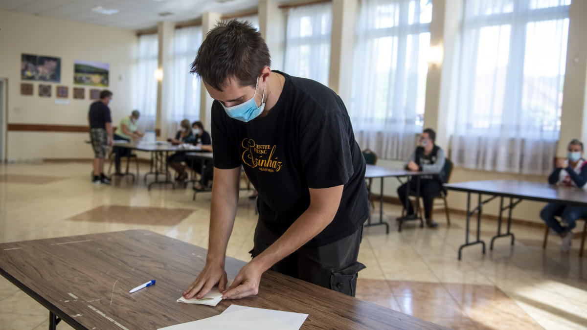 Összehajtja szavazólapját egy férfi az időközi önkormányzati választáson a Nógrád megyei Vizsláson, a közösségi házban kialakított szavazókörben 2020. szeptember 13-án. A koronavírus-járvány terjedésének megakadályozásáért a szavazóhelyiségekben kézfertőtlenítőt helyeztek el, amelyet a választópolgárok a szavazóhelyiségbe érkezéskor és távozáskor is használhatnak. A szavazatszámláló bizottságok tagjai maszkot viselnek, és erre kérik a választópolgárokat is.