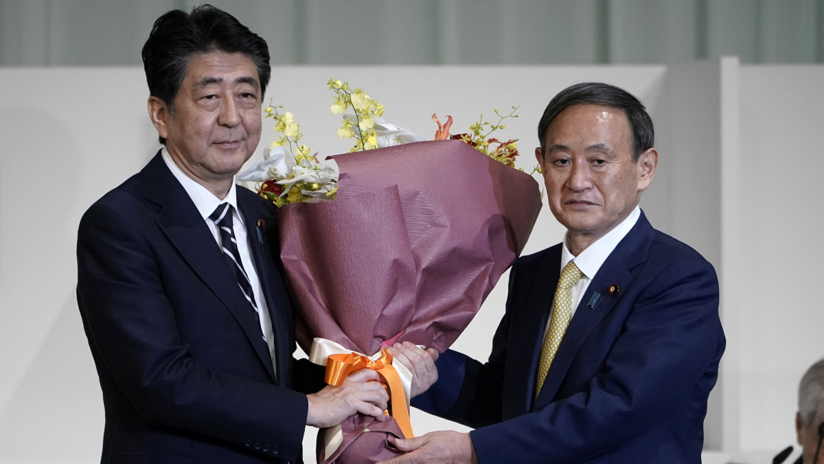 Abe Sindzó japán miniszterelnök (b) virágot nyújt át Szuga Josihide kormányszóvivőnek, miután utóbbi  megnyerte a japán kormánypárt, a Liberális Demokrata Párt (LDP) új vezetőjének megválasztására kiírt szavazást Tokióban 2020. szeptember 14-én. Várhatóan a kormánypárt új vezetője lesz az új miniszterelnök az egészségi okok miatt augusztus 28-án lemondó Abe Sindzó után.
