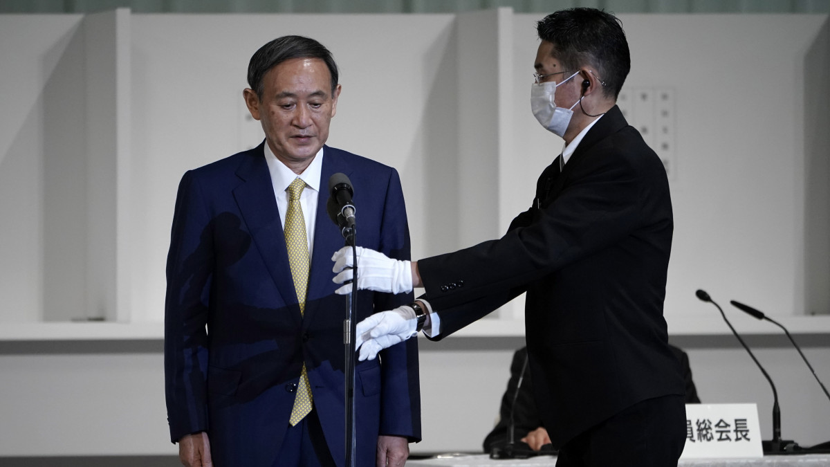 Szuga Josihide kormányszóvivő (b) egy mikrofon előtt áll a színpadon, miután megnyerte a japán kormánypárt, a Liberális Demokrata Párt (LDP) új vezetőjének megválasztására kiírt szavazást Tokióban 2020. szeptember 14-én. Várhatóan a kormánypárt új vezetője lesz az új miniszterelnök az egészségi okok miatt augusztus 28-án lemondó Abe Sindzó után.