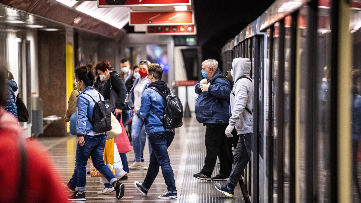Védőmaszkot viselő utasok szállnak le a metróról a Széll Kálmán téri állomáson 2020. április 27-én. Ettől a naptól csak sállal, kendővel vagy maszkkal eltakart arccal szabad felszállni a fővárosi tömegközlekedés járataira, s így lehet csak boltba menni és taxival utazni a koronavírus-járvány terjedésének megakadályozása érdekében. Az intézkedés nem vonatkozik a 6 éven aluli utasokra. A rendelkezés betartásának elősegítése érdekében a Budapesti Közlekedési Központ (BKK) és a Főpolgármesteri Hivatal több csomópontban mosható és vasalható textilmaszkot oszt az utazóknak.