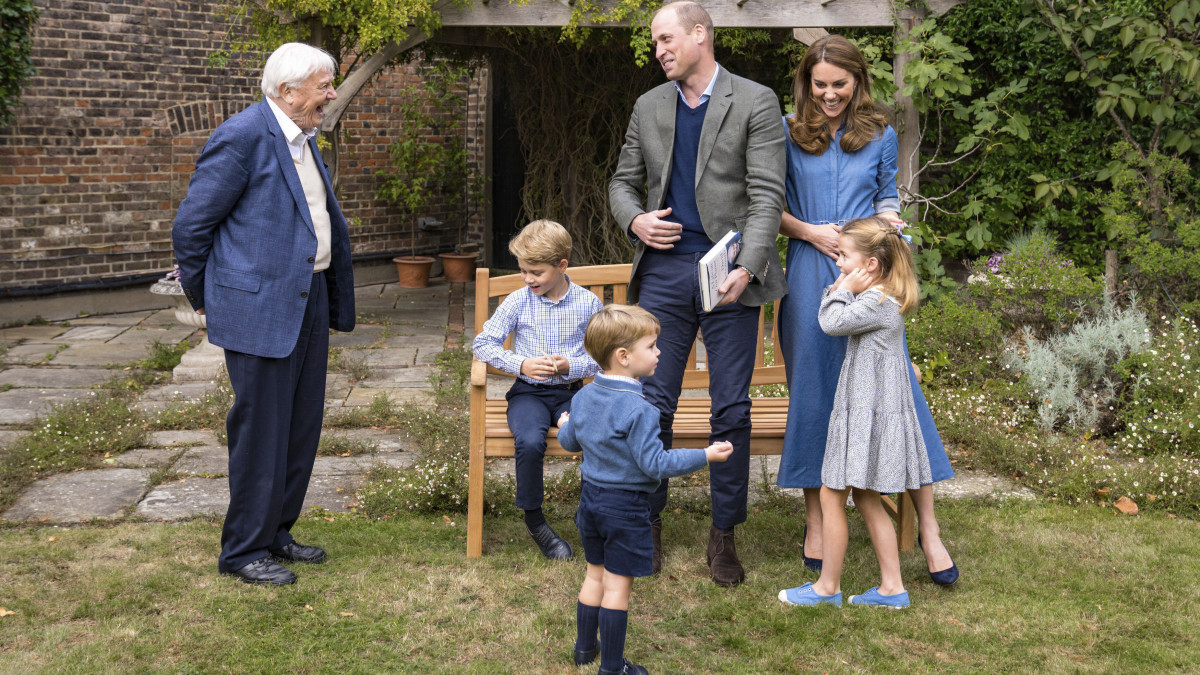 A Kensington-palota által 2020. szeptember 24-én közreadott képen Vilmos cambridge-i herceg (k) és felesége, Katalin hercegnő (j) fogadja David Attenborough brit természettudóst (b) a londoni Kensington-palota kertjében. Körülöttük három gyermekük, György (ül) és Lajos herceg (elöl), valamint Sarolta hercegnő (j). Az eseményen levetítették a hamarosan a mozikba kerülő David Attenborough: A Life On Our Planet című dokumentumfilmet.