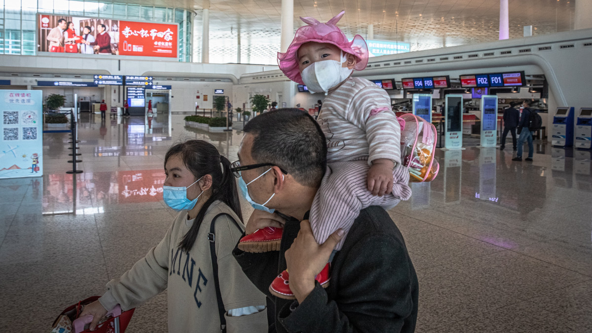 Család a vuhani Tienho Nemzetközi Repülőtéren 2020. április 8-án, miután feloldották az új koronavírus miatt elrendelt vesztegzárat Hupej tartomány székhelyén. A koronavírus világjárványa Vuhanból indult ki.
