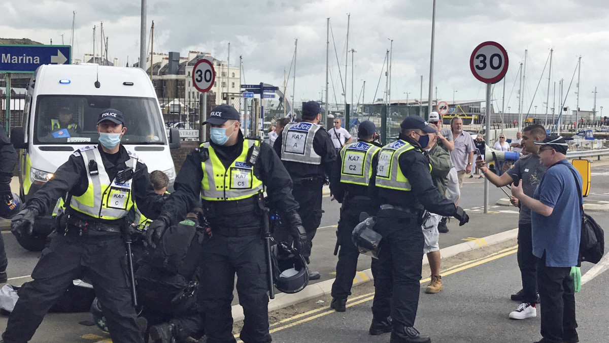 Brit rendőrök őrizetbe veszik az illegális bevándorlás ellen tiltakozó tüntetők egyikét a délkelet-angliai Doverben 2020. szeptember 5-én.
