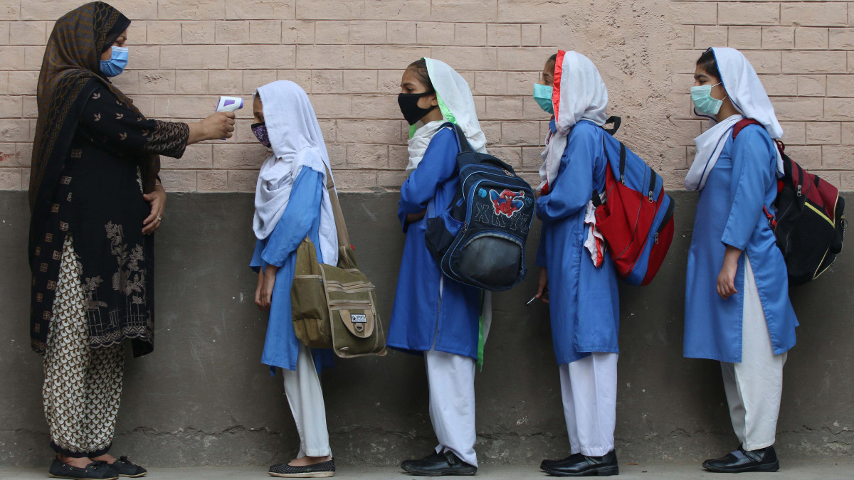 Pakisztáni diáklányok testhőmérsékletét mérik egy pesavari iskolában a tanítás első napján, 2020. szeptember 30-án. Pakisztánban a koronavírussal fertőzöttek számának csökkenése miatt szeptember 30-tól az általános iskolákban is újra megkezdődött az oktatás.