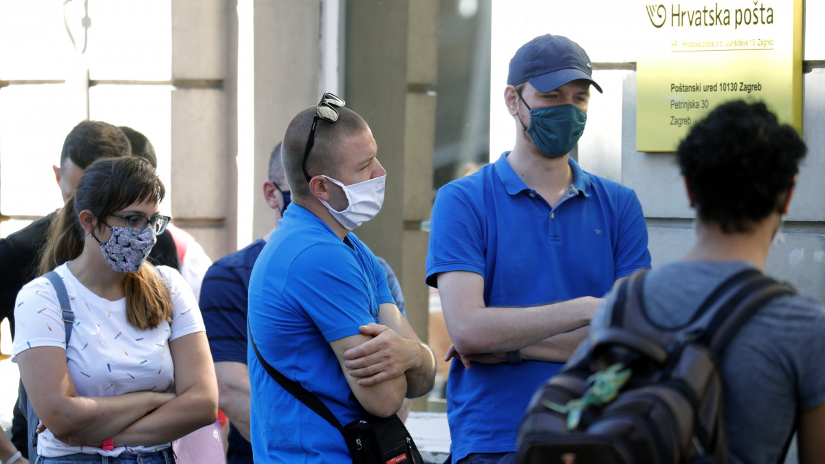 Védőmaszkos ügyfelek egy zágrábi posta előtt 2020. július 13-án. Ettől a naptól a koronavírus-járvány miatt kötelező a szájmaszk viselése az egészségügyi intézményekben, a közösségi közlekedési eszközökön és az üzletekben.