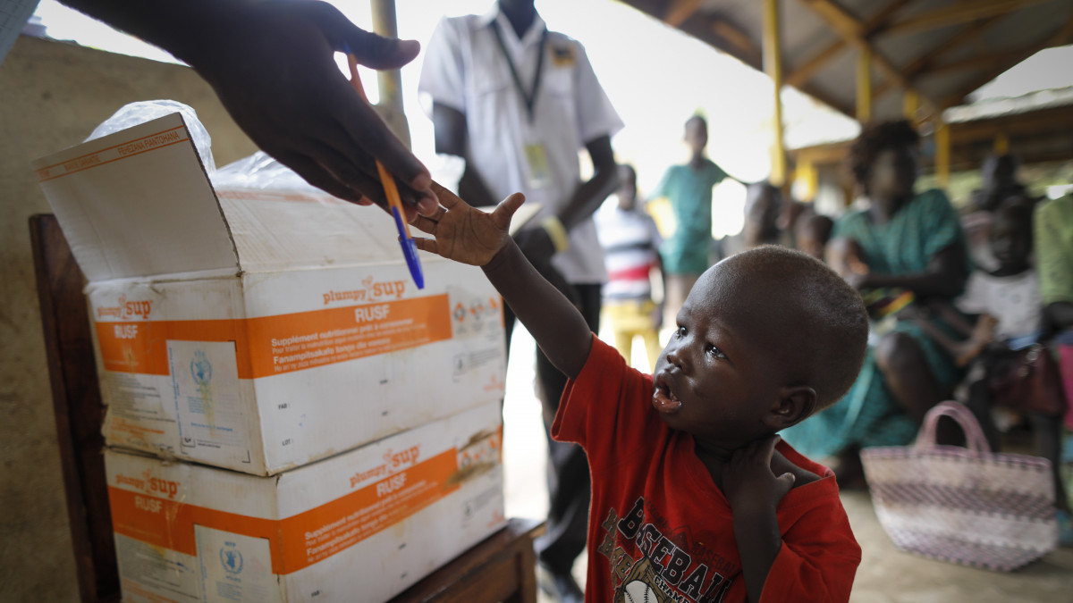 2019. június 25-én készült kép egy szudáni kisfiúról egy segélyelosztóhelyen az északnyugat-kenyai Kakuma menekülttáborban. A Kakuma a világ legnagyobb menekülttábora, ahova az elmúlt években több tízezren érkeztek a környező országokból, Dél-Szudánból, Ugandából, Tanzániából, Burundiból és Malawiból. Az ENSZ Világélelmezési Program (WFP) nevű segélyszervezetének jelentése szerint a Kakuma táborban és a szomszédos Kalobeyei táborban élő, több mint 180 ezer menekült több mint 10 százaléka szenvedett akut alultápláltságban 2017-ben.