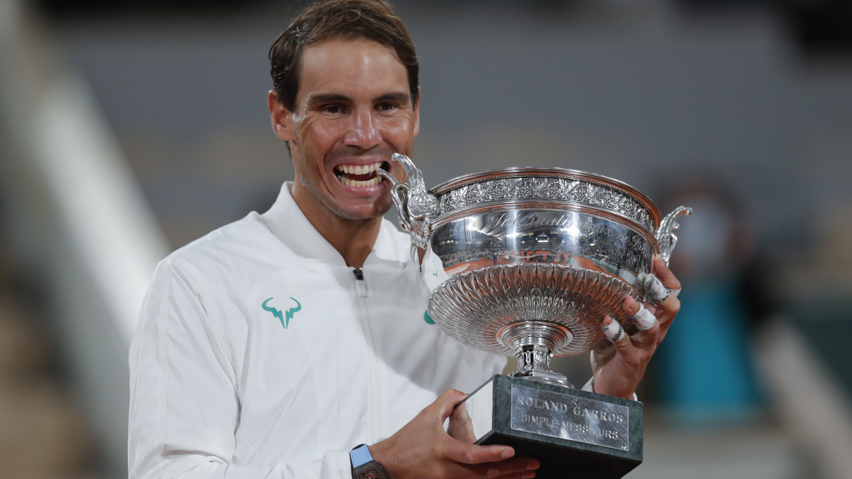 A győztes spanyol Rafael Nadal ünnepel a bajnoki trófeával, miután 6:0, 6:2, 7:5 arányban győzött a szerb Novak Djokovic ellen a francia nyílt teniszbajnokság férfi egyesének döntőjében a párizsi Roland Garros Stadionban 2020. október 11-én.