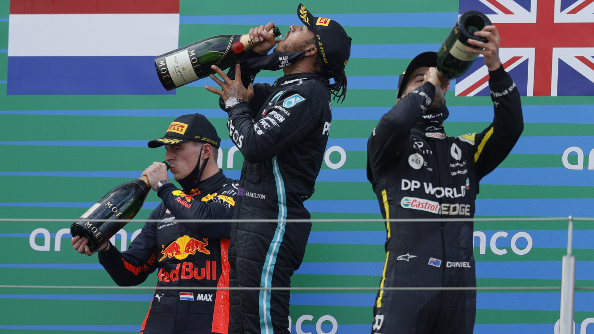 A győztes Lewis Hamilton, a Mercedes brit versenyzője (k), a második helyezett holland Max Verstappen, a Red Bull (b) és a harmadik helyezett ausztrál Daniel Ricciardo, a Renault versenyzője pezsgővel ünnepel a Forma-1-es autós gyorsasági világbajnokság Eifel Nagydíjának eredményhirdetésén a nürburgi Nürburgring versenypályán 2020. október 11-én.