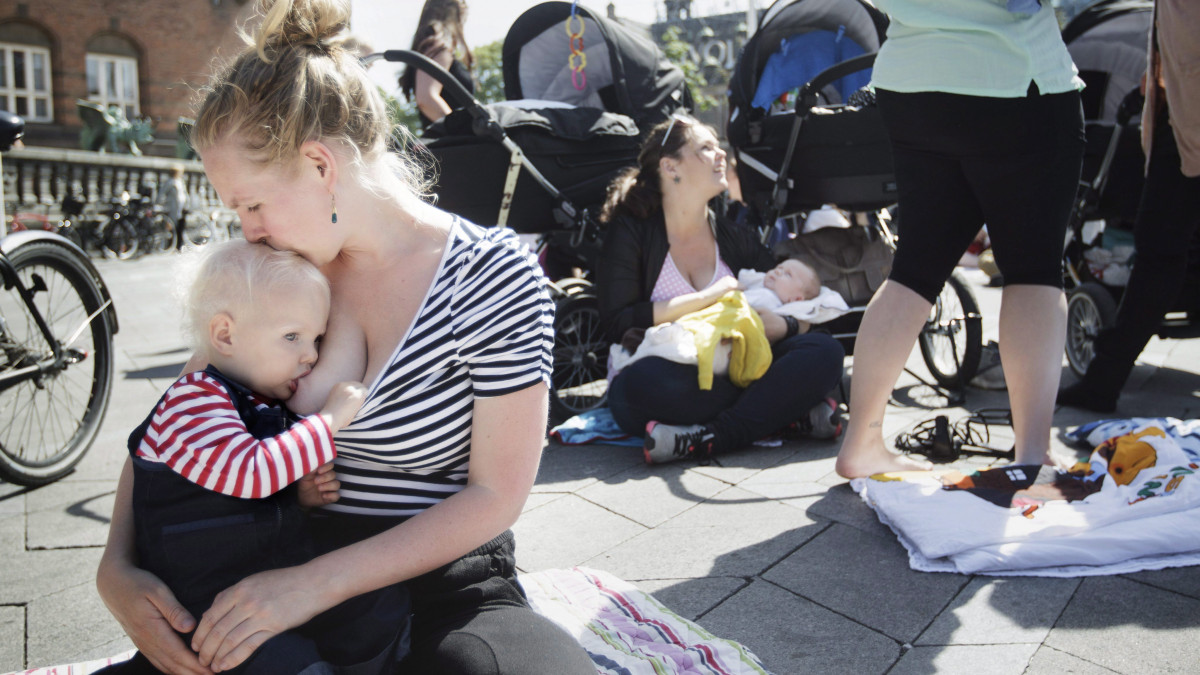 Koppenhága, 2013. június 17.Gyermekét eteti egy nő a koppenhágai Városháza téren a nyilvános szoptatás lehetősége mellett tüntetve 2013. június 17-én. A több száz fős demonstráció előzményeként egy kávéház vendégei rászóltak egy csecsemőjét szoptató nőre, hogy gusztutalan, amit csinál. (MTI/EPA/Mads Nissen)