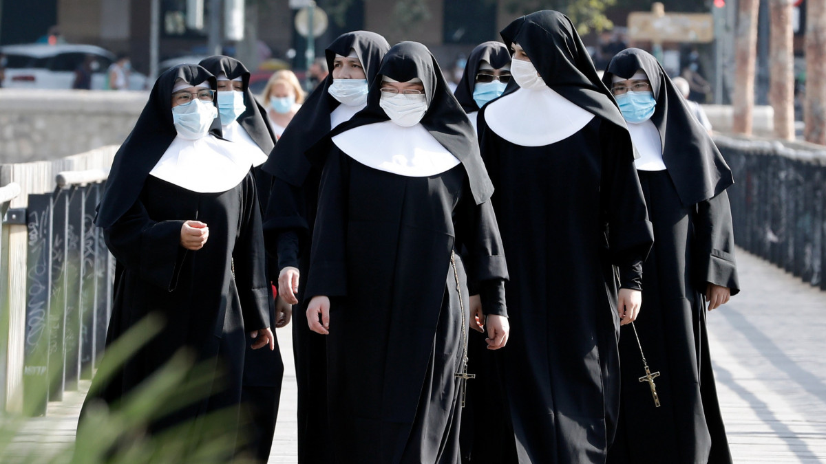 Védőmaszkot viselő apácák sétálnak egy utcán a kelet-spanyolországi Valenciában 2020. július 29-én. A koronavírus-járvány újabb hullámának megelőzése érdekében a helyi hatóságok kötelezővé tették a maszk viselését a közterületeken.