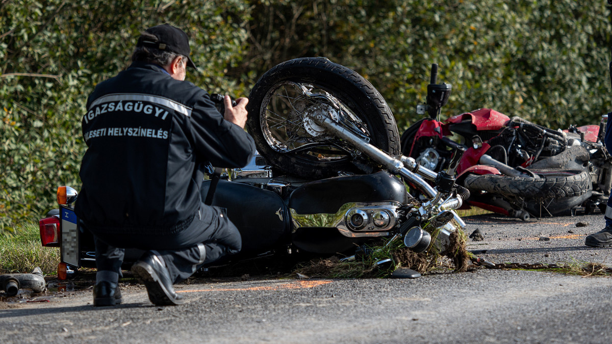 Összeroncsolódott motorkerékpárok mellett helyszínel egy rendőr az 51-es főút 140-es kilométerénél, Dusnok közelében 2020. október 23-án, miután egy autó összeütközött a két motorkerékpárral. A két motoros a helyszínen meghalt.