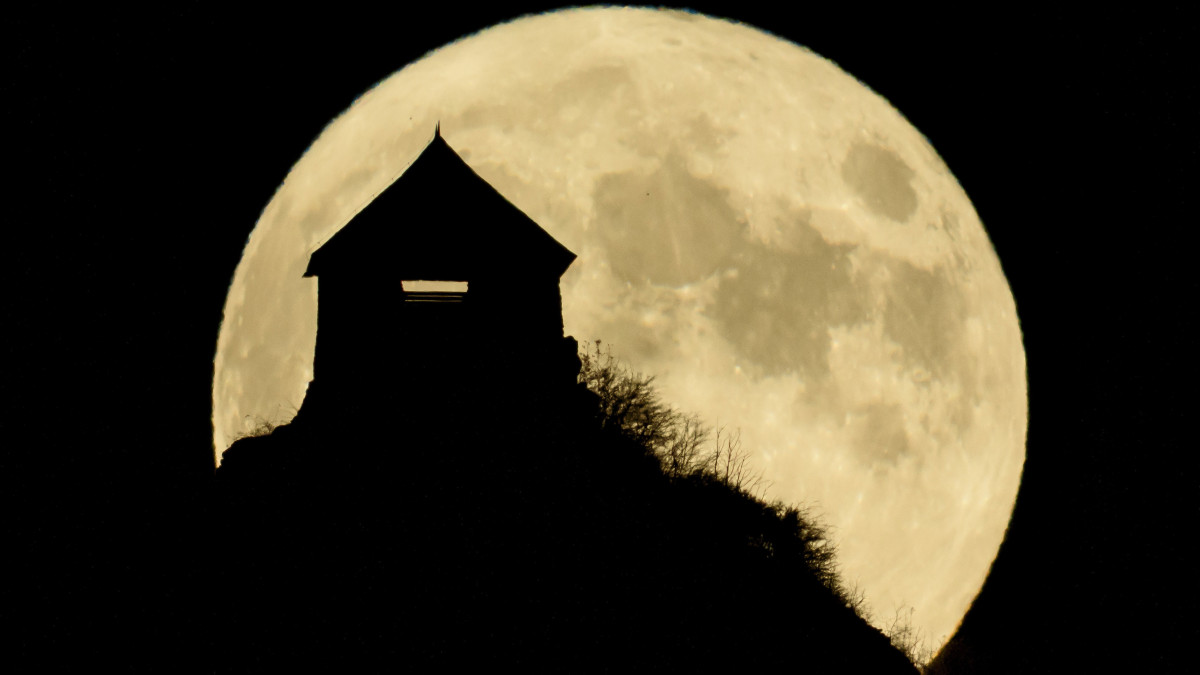 A felkelő Hold látszik a salgói vár mögött Salgótarján közeléből fotózva 2020. október 31-én.