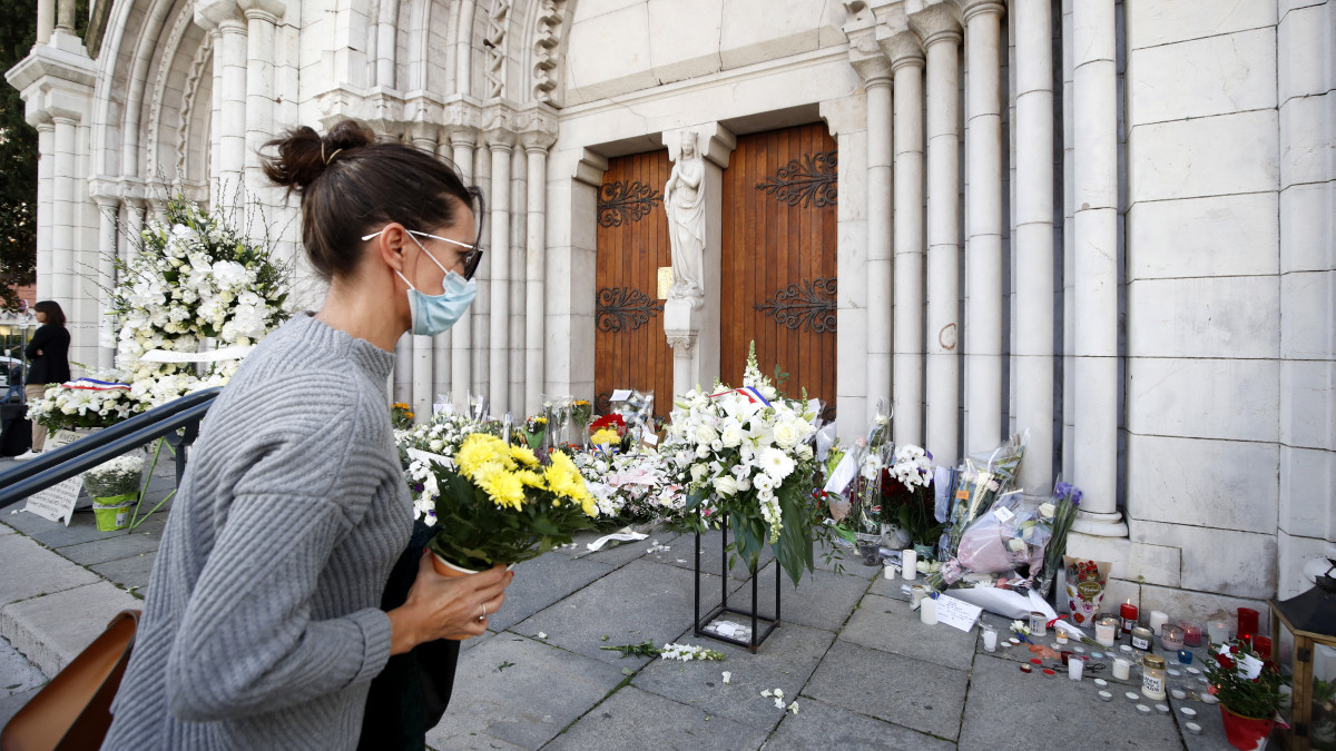 Virágok és mécsesek a nizzai Notre-Dame-bazilika előtt 2020. október 30-án, egy nappal a nizzai merénylet után. Brahim Ausszaui 21 éves tunéziai bevándorló késsel támadt a bazilikában tartózkodó három emberre, egy idős nőt lefejezett, a sekrestyést és egy másik nőt halálosan megsebesített. Franciaországban a legmagasabb szintre emelték a terrorkészültséget a támadást követően.