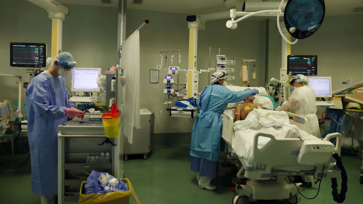 Védőmaszkot és arcpajzsot viselő egészségügyi dolgozók ellátnak egy beteget a koronavírus-fertőzöttekkel foglalkozó intenzív osztályon egy bergamói kórházban 2020. november 3-án.