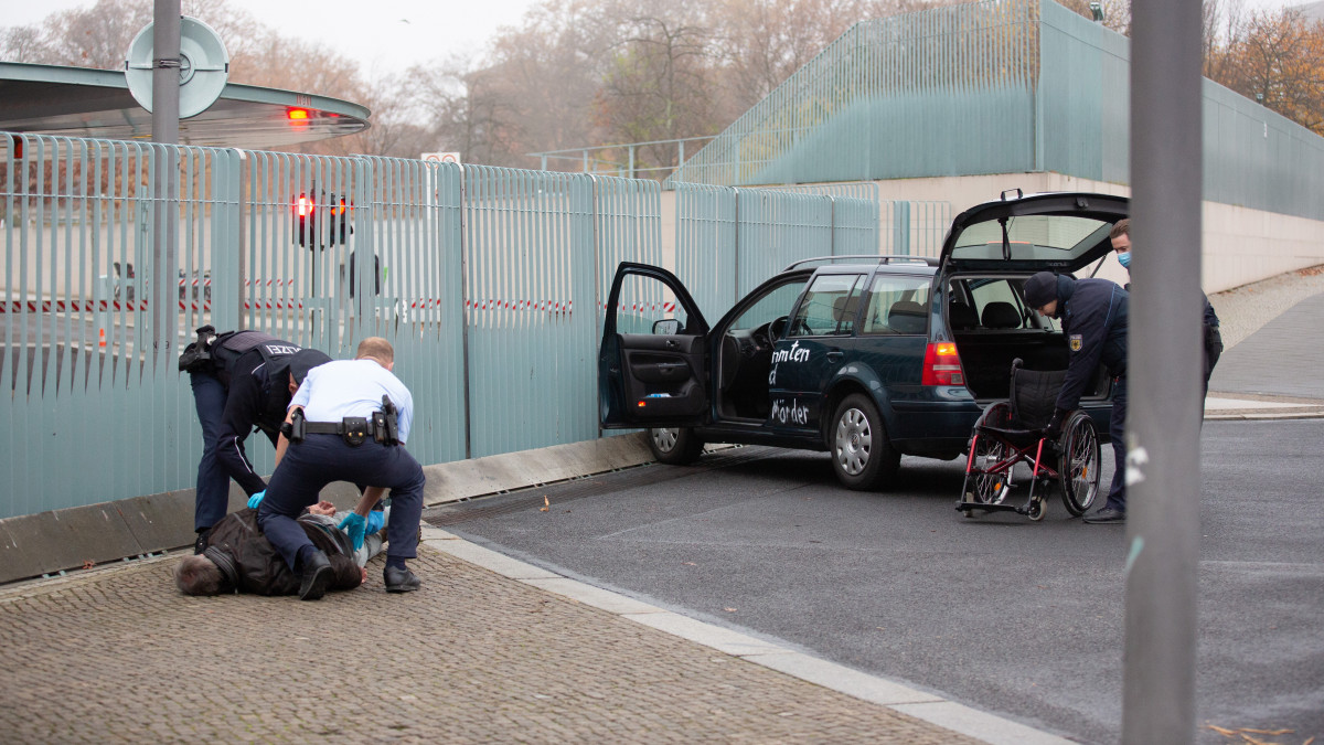 Rendőrök őrizetbe vesznek egy férfit, aki autójával nekihajtott a berlini kancellári hivatal kapujának 2020. november 25-én.
