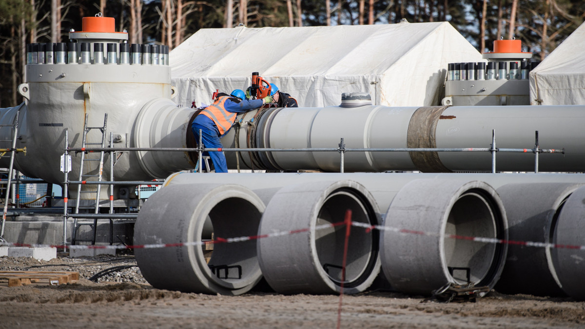 Munkások dolgoznak az orosz földgázt Ukrajna és Lengyelország megkerülésével Németországba szállító Északi Áramlat-2 gázvezeték fogadóállomásánál a németországi Lubminban 2019. március 26-án. Finnország partvidékénél 2018 szeptemberében kezdődött meg az Oroszországot Németországgal összekötő földgázvezeték tengeri szakaszának lefektetése. Az Északi Áramlat-2 egy 9,5 milliárd eurós projekt, amelynek keretében két új, összesen évi 55 milliárd köbméter szállítási kapacitású vezetékkel bővítik a Balti-tenger fenekén húzódó Északi Áramlatot, amelynek vezetéke az oroszországi Viborgból indul és a németországi Greifswald mellett fekvő Lubminnál éri el a német partot. A gázvezetékből már 600 kilométert, a teljes hossznak mintegy a felét már lefektették.