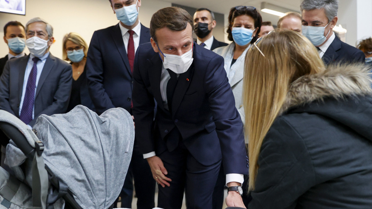 Emmanuel Macron francia elnök (k) Frederique Vidal felsőoktatási, innovációs és kutatási miniszter (j3) és Olivier Véran szociális és egészségügyi miniszter (b4) jelenlétében egy látogatót üdvözöl a párizsi Necker Kórház Imagine Intézetében a koronavírus-járvány idején, 2020. december 4-én.