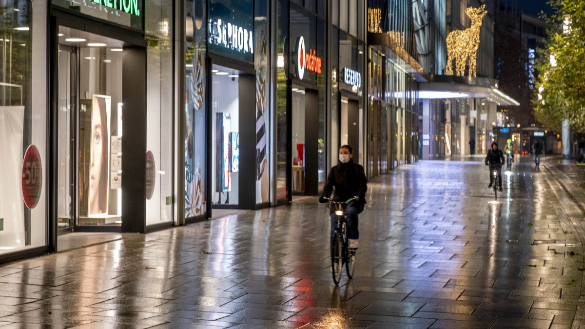 A koronavírus-járvány miatt védőmaszkot viselő nő kerékpározik Frankfurt elnéptelenedett utcáján 2020. december 16-án. Németországban a vírus rohamosan gyorsuló terjedése miatt ettől a naptól csak a mindennapi élethez elengedhetetlen cikkeket árusító boltok tarthatnak nyitva, a létfenntartáshoz szükséges minimumra korlátozták a szolgáltatásokat, az iskolákban ügyeleti rendszert vezettek be, és felkérték a munkaadókat, hogy a lehető legszélesebb körben tegyék lehetővé az otthoni munkavégzést.