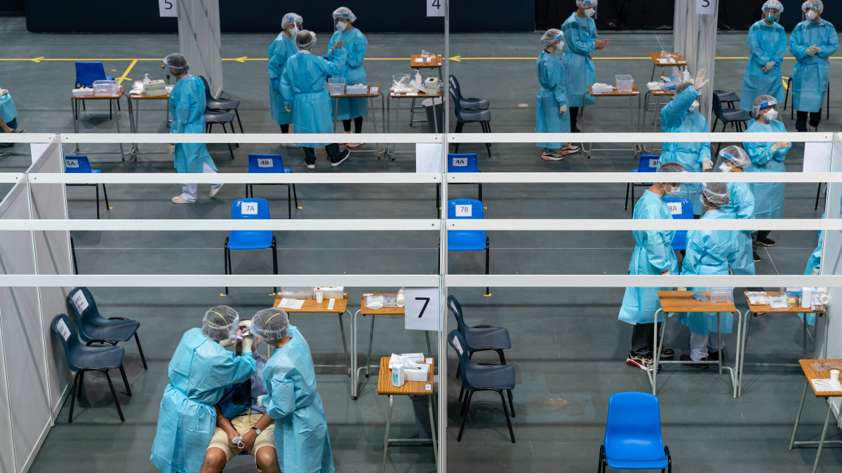 Koronavírus-teszthez vesznek mintát egy férfitől a hongkongi Erzsébet királynő stadionban kialakított tesztállomáson 2020. szeptember 1-jén. A hatóságok az önkéntes alapú tömeges teszteléssel a koronavírus-járvány harmadik hullámát szeretnék megelőzni.