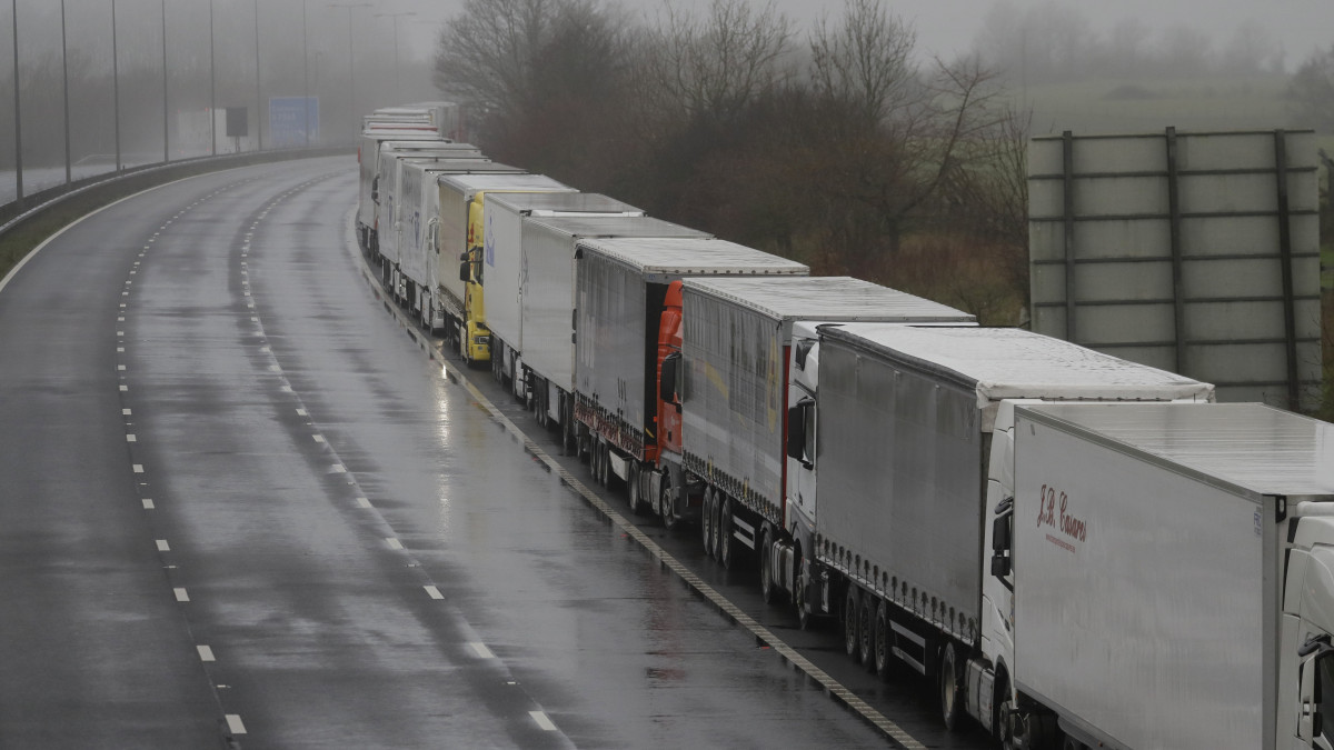 Parkoló kamionok sora az úton, Folkestone közelében 2020. december 21-én, miután a doveri kikötőt bezárták. Ennek oka, hogy a Nagy-Britanniában felbukkant új koronavírus-változat gyors terjedése miatt a francia kormány éjféltől 48 órára megtiltotta mindenkinek, a teherautóvezetőket is beleértve a beutazást a szigetországból.