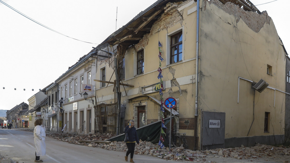 Emberek egy megrongálódott épület előtt Petrinjában 2020. december 29-én, miután 6,3 erősségű földrengés volt Közép-Horvátországban. Egy gyermek életét vesztette, feltehetőleg többen megsérültek.