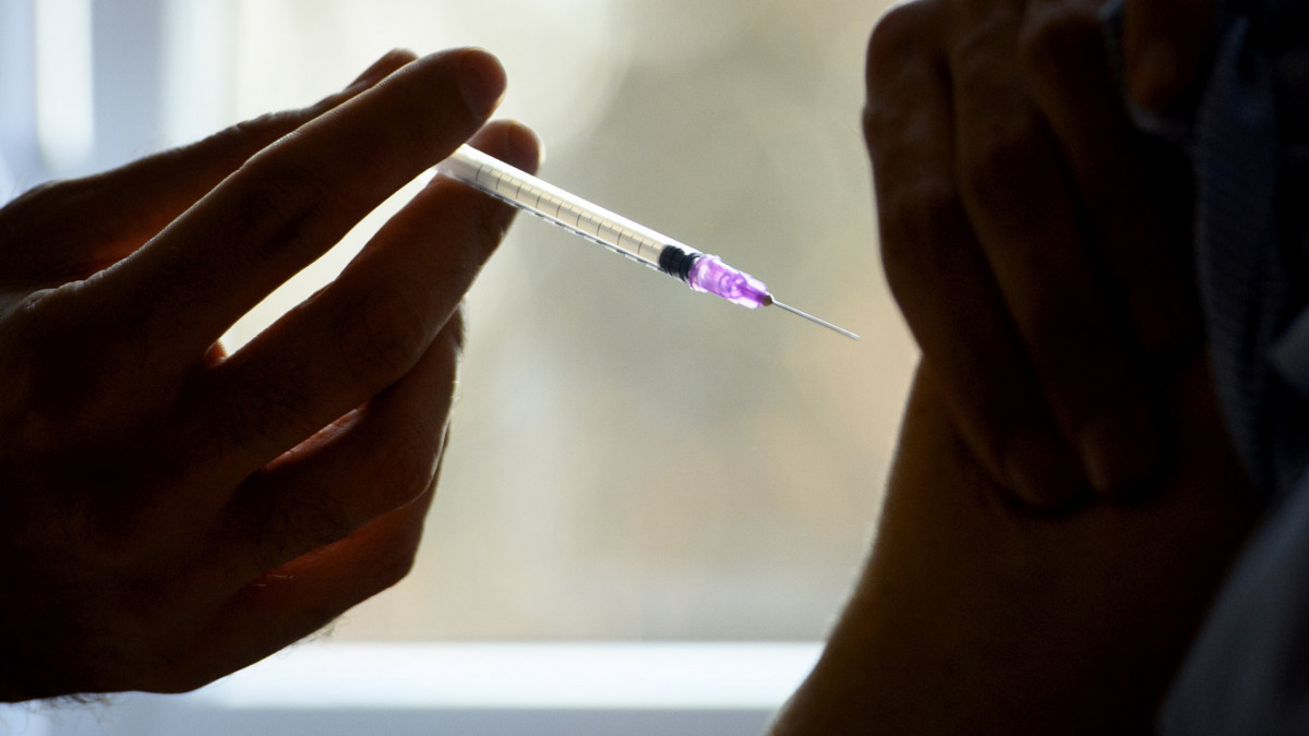 A Pfizer és a BioNTech gyógyszeripari vállalatok koronavírus elleni vakcináját adják be egy asszonynak a svájci Morges kórházában kialakított oltóközpontban 2021. január 11-én. A svájci Vaud kantonban ezen a napon kezdték meg a koronavírus elleni védőoltások beadását.