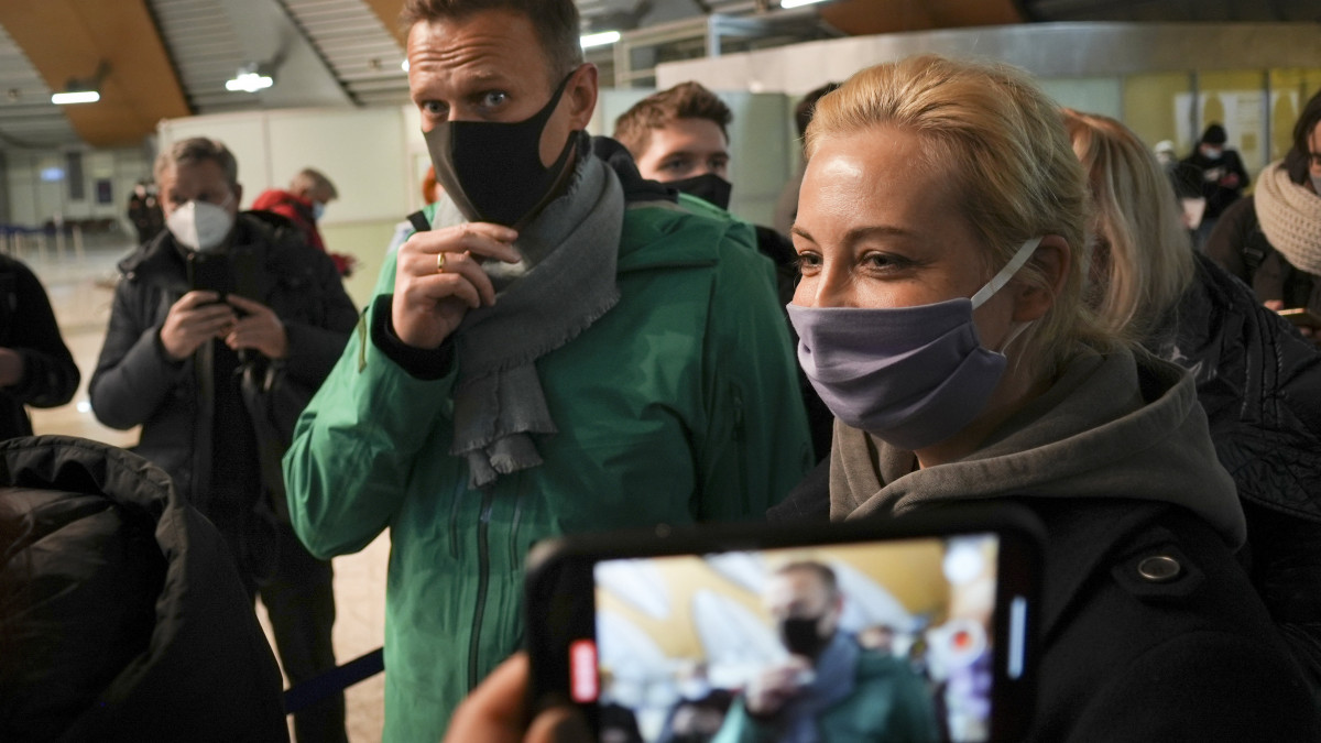 Alekszej Navalnij orosz ellenzéki politikus (k) és felesége, Julia megérkezik a Moszkva közelében lévő seremetyjevói repülőtérre 2021. január 17-én. Navalnijt a repülőtéren őrizetbe vették és elvezették a rendőrök. Az orosz Szövetségi Büntetés-végrehajtási Szolgálat (FSZIN) korábban keresetet nyújtott be egy moszkvai bíróságon, amelyben kezdeményezte az úgynevezett Yves Rocher-ügyben Navalnijra kiszabott felfüggesztett börtönbüntetés letöltendővé változtatását.