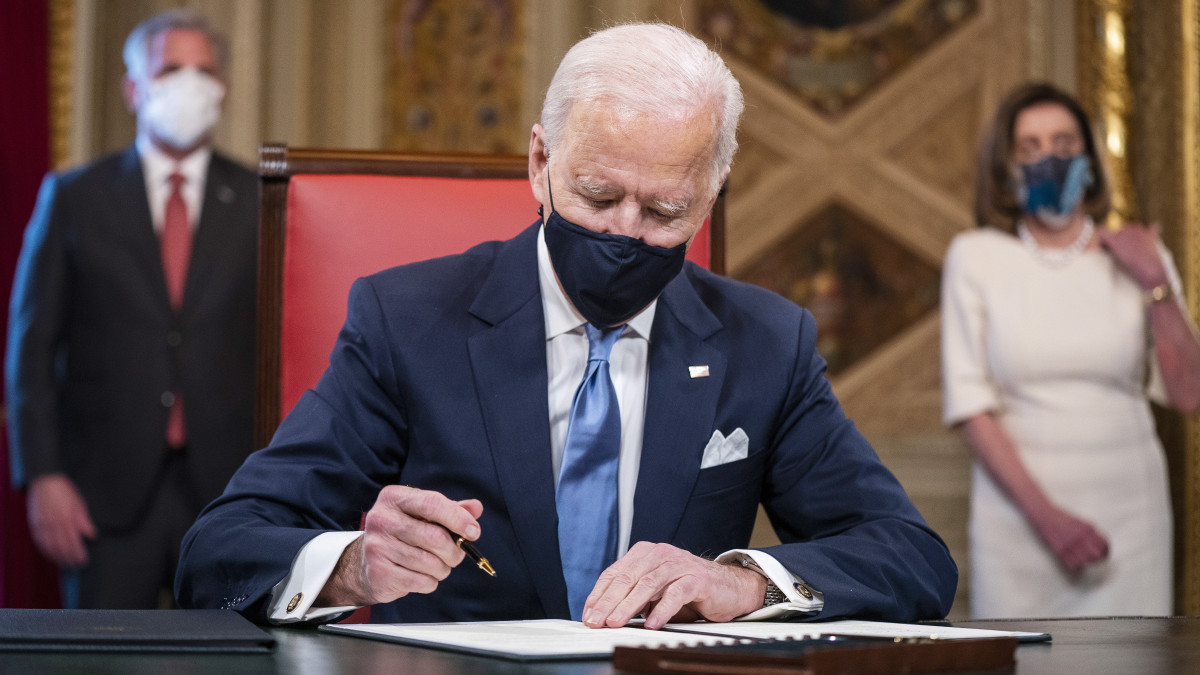 Joe Biden amerikai elnök aláírja a beiktatási, valamint a kormányzati tisztségekre jelölt személyek jelöléséről szóló dokumentumokat a törvényhozás washingtoni épületében, a Capitolium elnöki irodájában 2021. január 20-án, beiktatása napján.